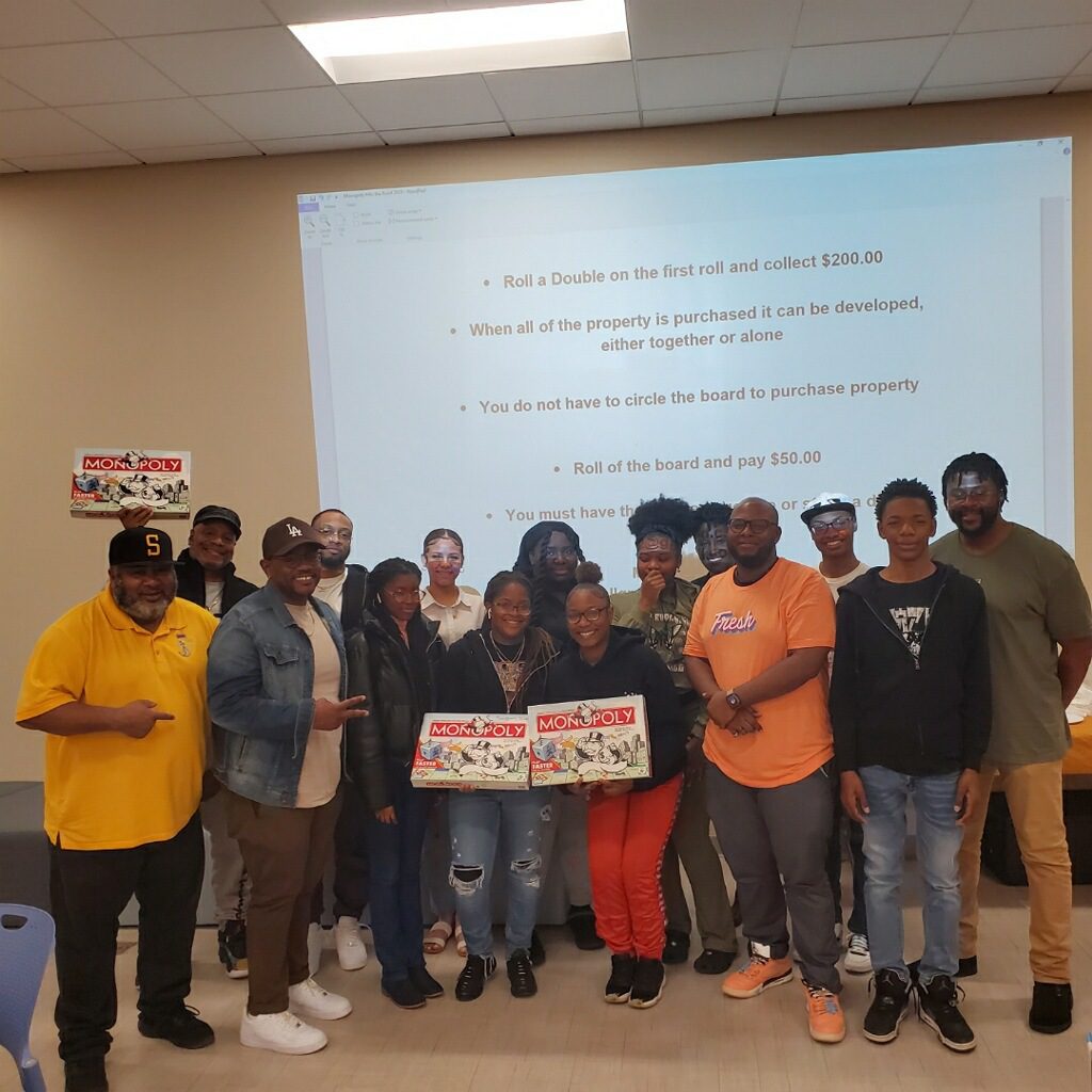 Two women from group of people holding monopoly board game